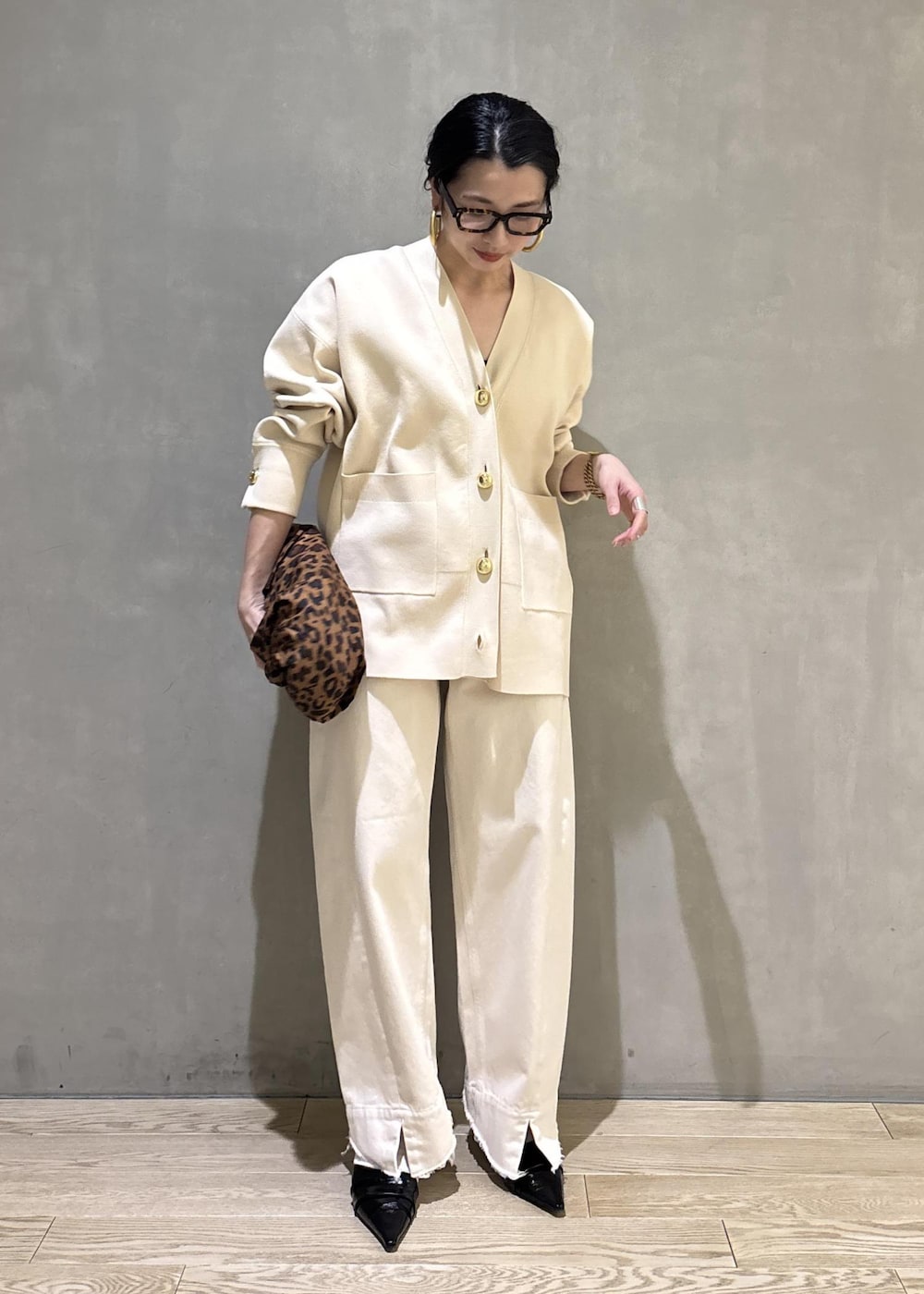 ブラック系のサンダル、ホワイト系のデニムパンツ、ホワイト系のカーディガン/ボレロを着用したレディースの冬コーディネートの3枚目の写真