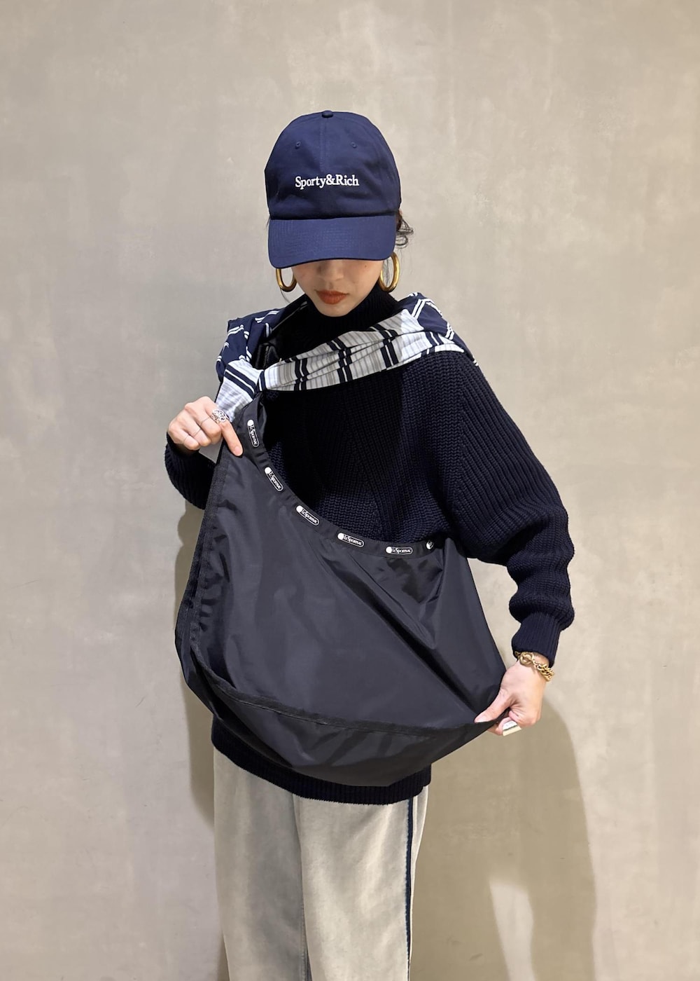 ブルー系のデニムパンツ、ブラック系のショルダーバッグを着用したレディースの秋コーディネートの7枚目の写真