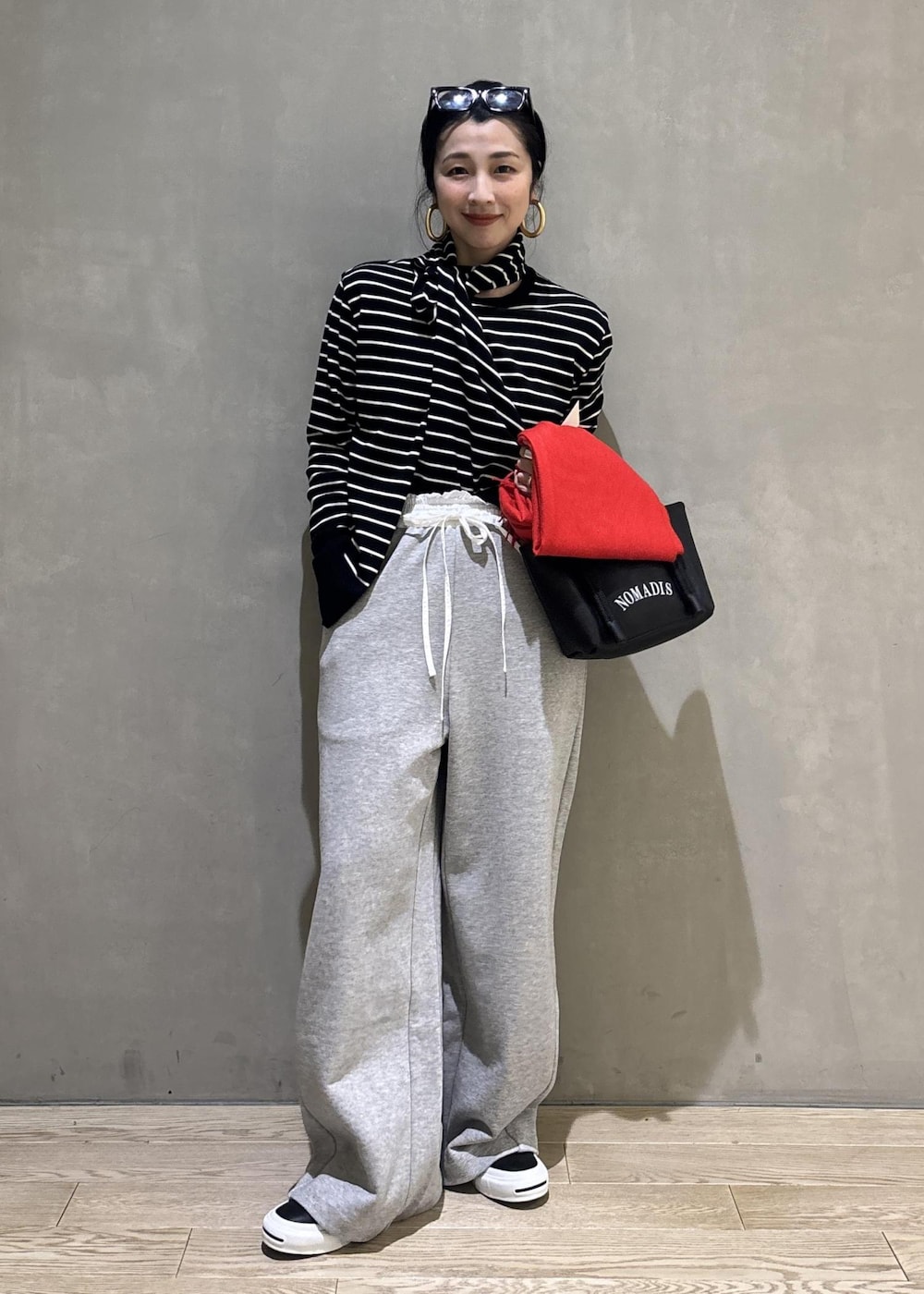 グレー系のその他パンツ、レッド系のマフラーを着用したレディースの冬コーディネートの3枚目の写真