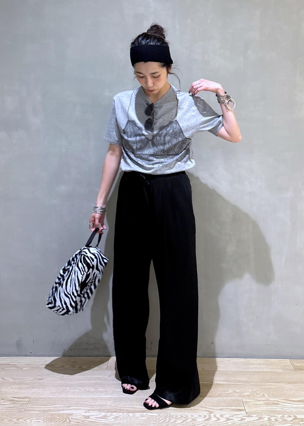 グレー系のTシャツ/カットソー、ブラック系のスラックス、ホワイト系のネックレスを着用したレディースの夏コーディネートの5枚目の写真