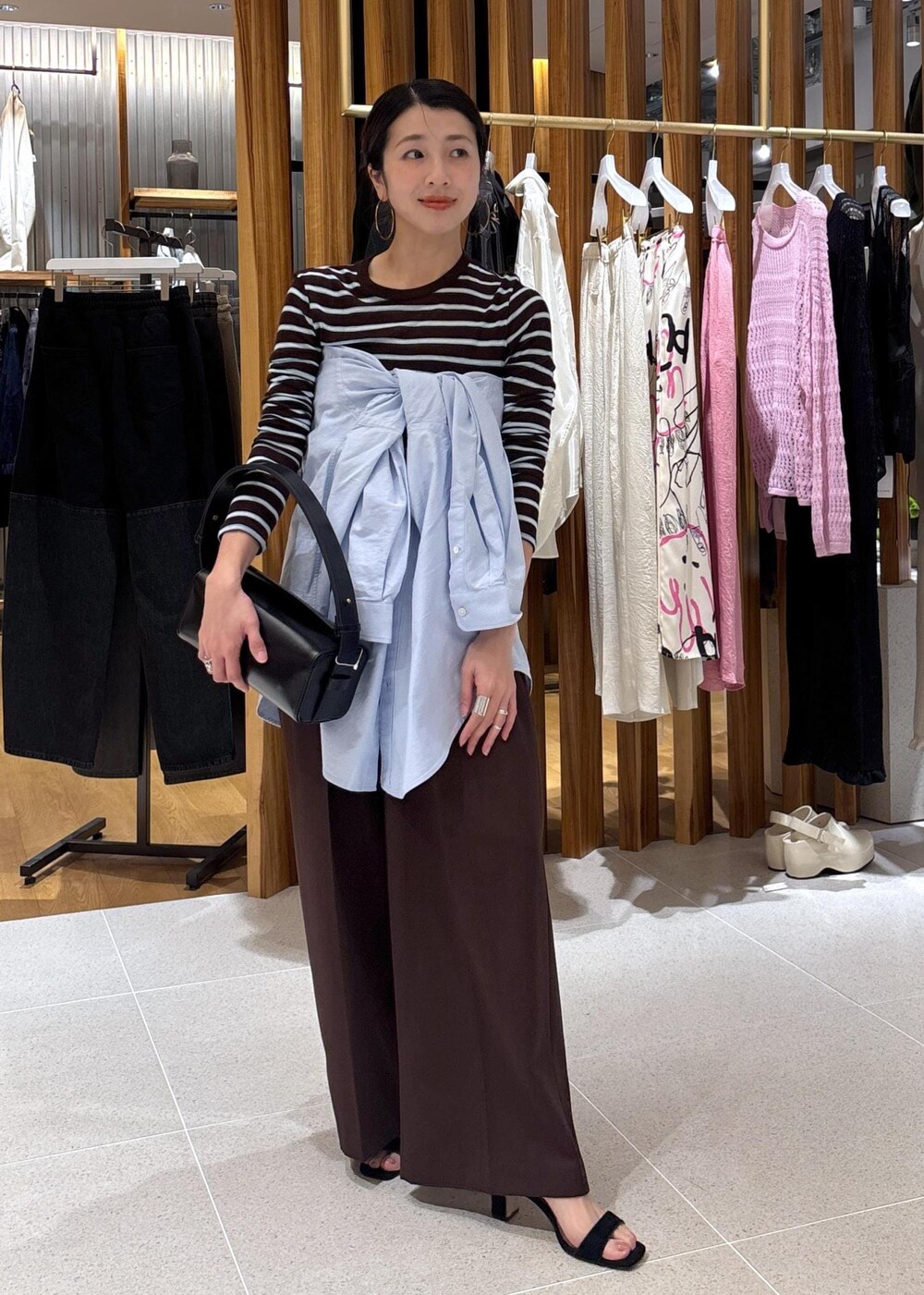 ブラック系のハンドバッグ、ブルー系のシャツ/ブラウス、ブラウン系のTシャツ/カットソーを着用したレディースの春コーディネートの7枚目の写真