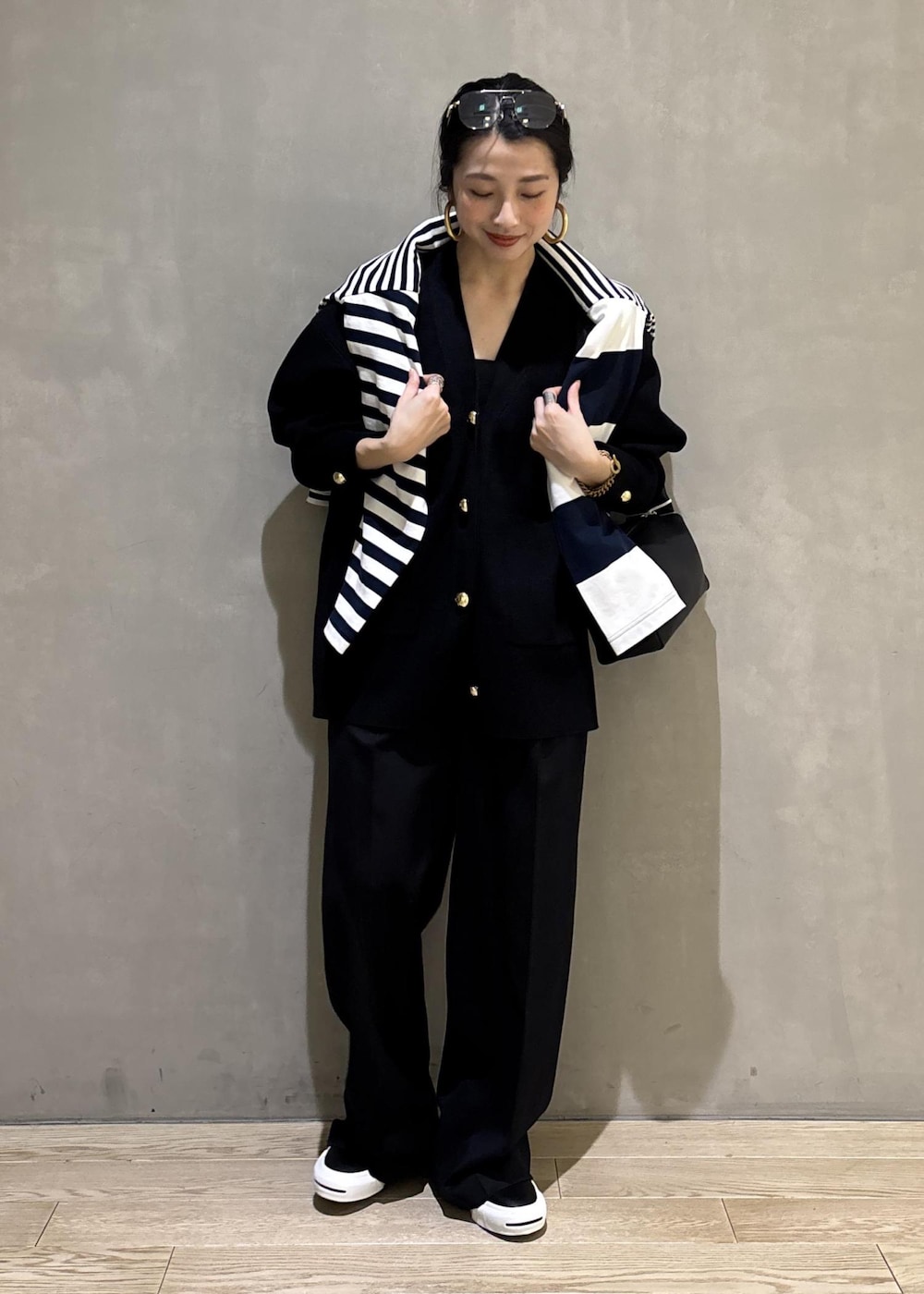 ブルー系のTシャツ/カットソー、ブラック系のカーディガン/ボレロ、ブラック系のスラックスを着用したレディースの冬コーディネートの6枚目の写真