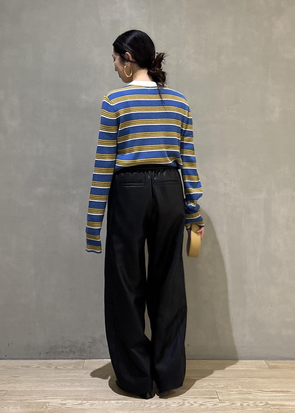 ブルー系のポロシャツ、ブラック系のその他パンツ、イエロー系のキーホルダーを着用したレディースの秋コーディネートの5枚目の写真