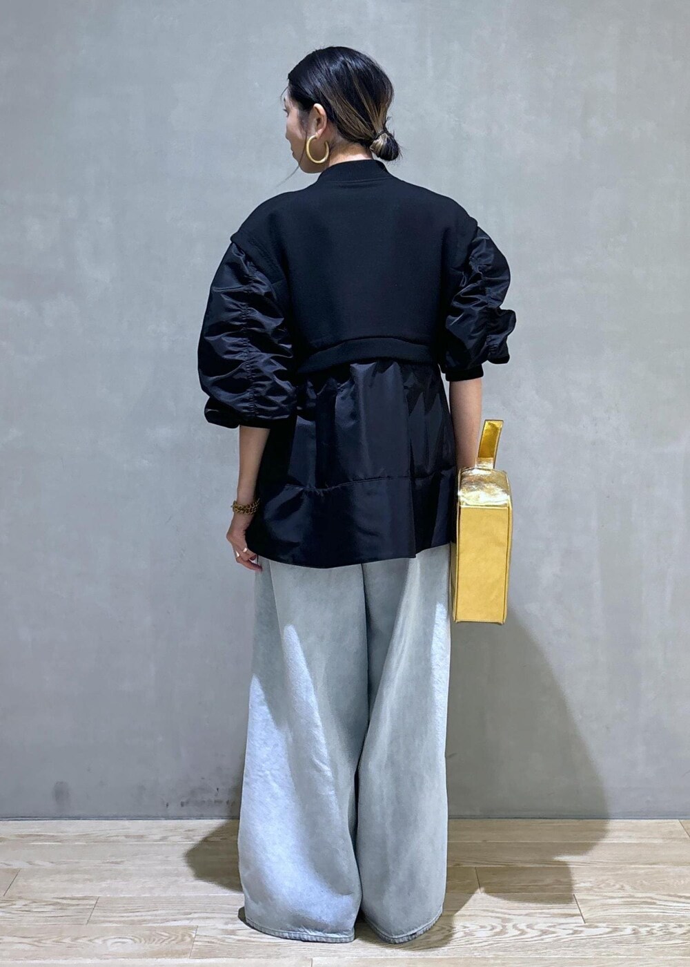 ゴールド系のショルダーバッグ、ブラック系のブルゾン、ホワイト系のTシャツ/カットソーを着用したレディースの秋コーディネートの7枚目の写真