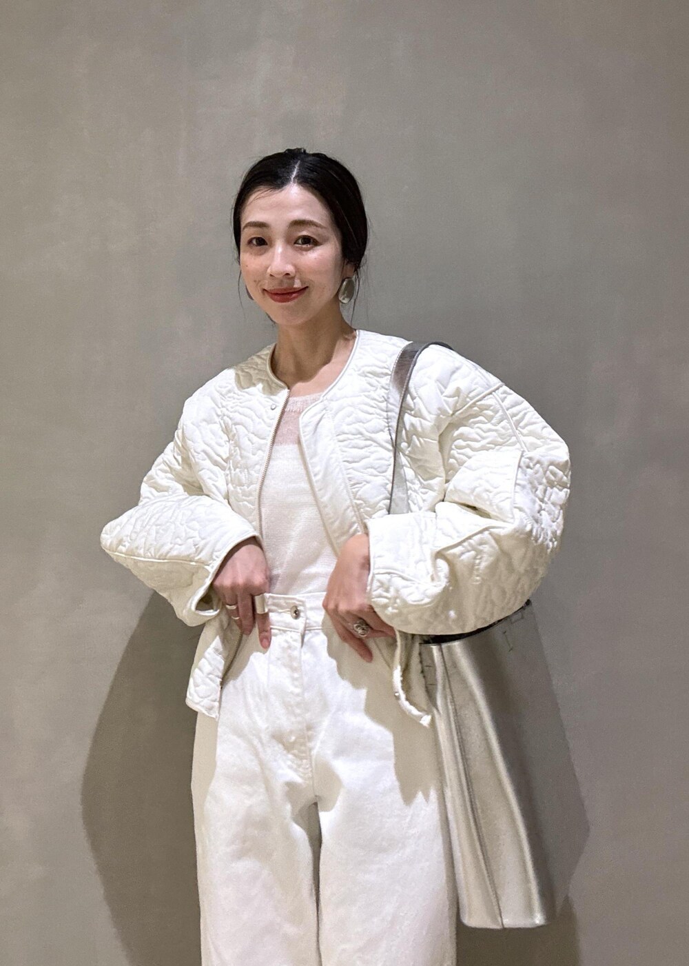 ホワイト系のパンプス、シルバー系のトートバッグ、ホワイト系のデニムパンツを着用したレディースの冬コーディネートの8枚目の写真