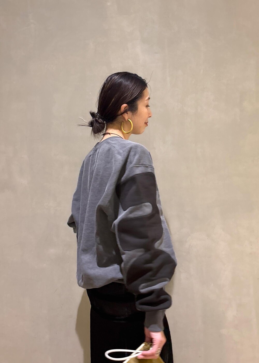 ブラック系のデニムパンツ、ブラック系のスカート、ベージュ系のポーチを着用したレディースの冬コーディネートの10枚目の写真