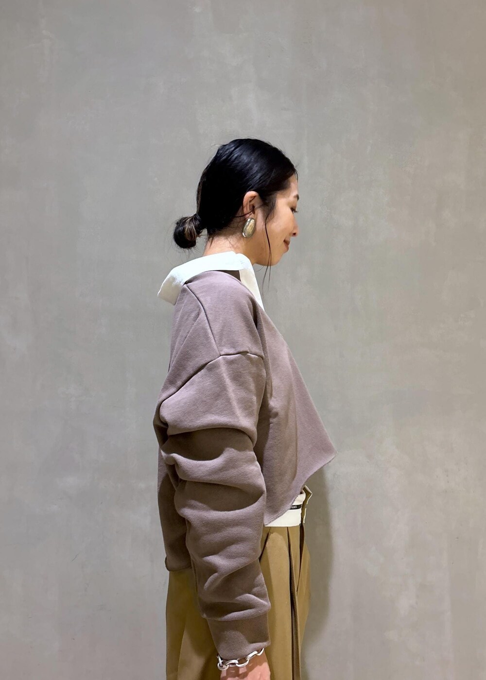 ブラック系のハンドバッグ、ブラウン系のサンダル、ベージュ系のTシャツ/カットソーを着用したレディースの秋コーディネートの7枚目の写真