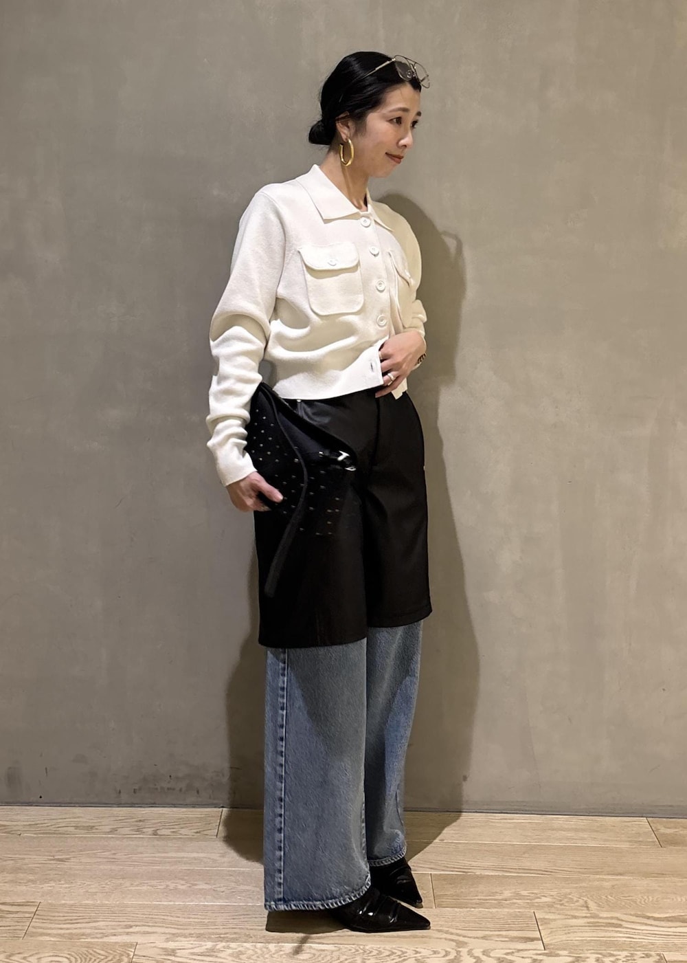 ブラック系のサンダル、ブルー系のデニムパンツ、ブラック系のダウンジャケット/コートを着用したレディースの冬コーディネートの4枚目の写真