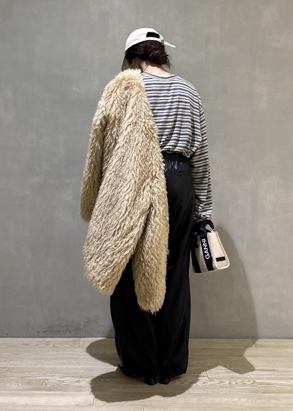 ベージュ系のトートバッグ、ベージュ系のその他アウター、ブラック系のその他パンツを着用したレディースの秋コーディネートの5枚目の写真