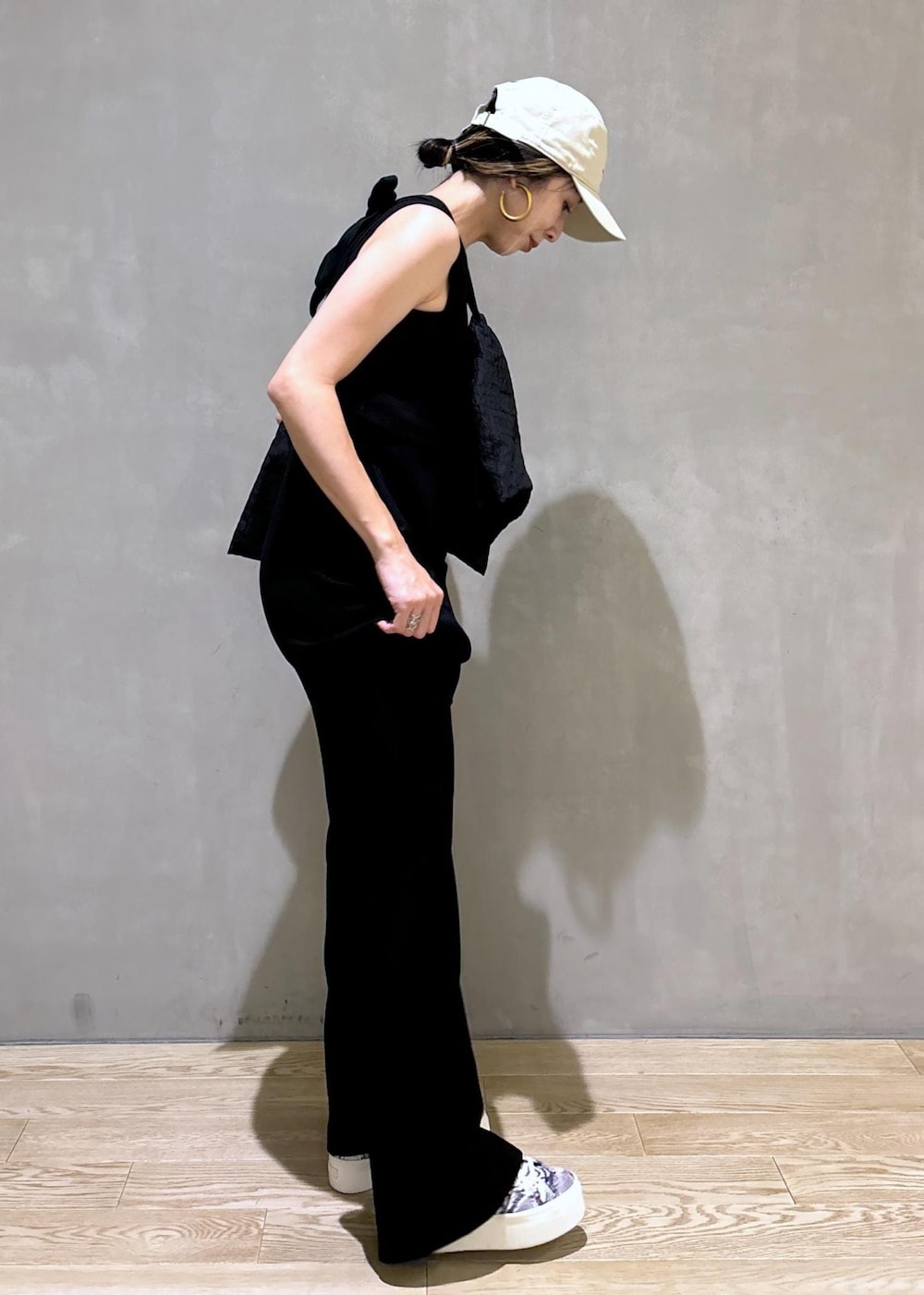 ブラック系のスニーカー、ブラック系のつなぎ/オールインワン、ベージュ系のキャップを着用したレディースの夏コーディネートの3枚目の写真