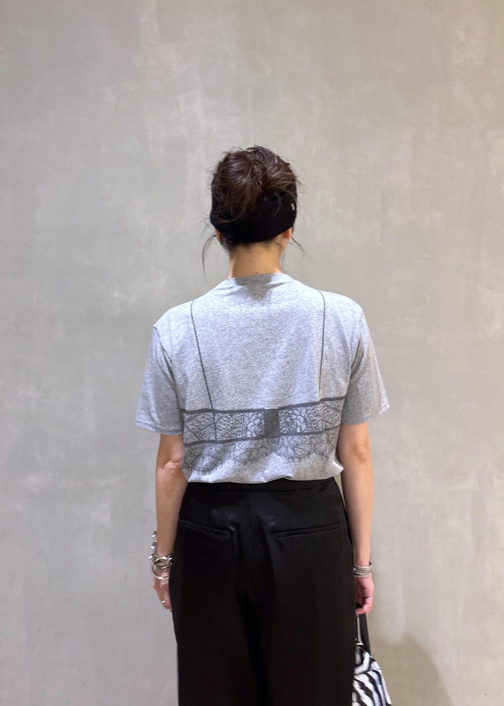 グレー系のTシャツ/カットソー、ブラック系のスラックス、ホワイト系のネックレスを着用したレディースの夏コーディネートの9枚目の写真