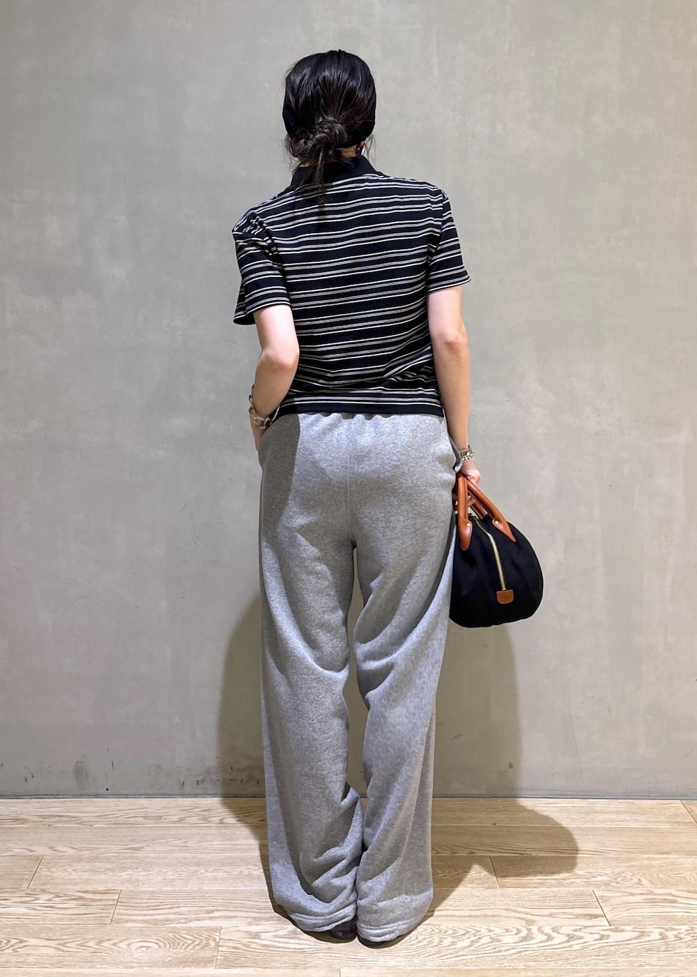 グレー系のスウェットパンツ、ブラック系のポロシャツを着用したレディースの夏コーディネートの6枚目の写真