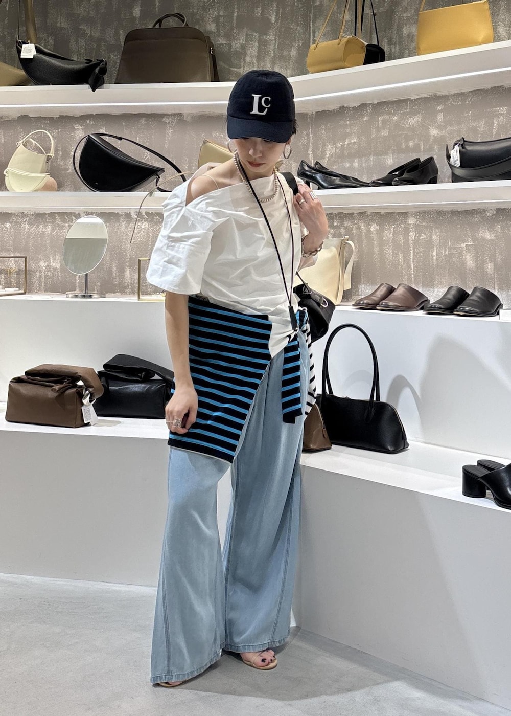 ブルー系のデニムパンツ、ブラック系のショルダーバッグ、ブルー系のTシャツ/カットソーを着用したレディースの春コーディネートの6枚目の写真