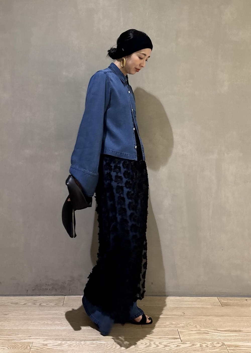 ブルー系のシャツ/ブラウス、ブルー系のデニムパンツ、ブラック系のクラッチバッグを着用したレディースの冬コーディネートの3枚目の写真