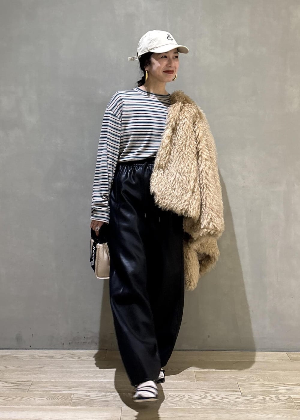 ベージュ系のトートバッグ、ベージュ系のその他アウター、ブラック系のその他パンツを着用したレディースの秋コーディネートの2枚目の写真