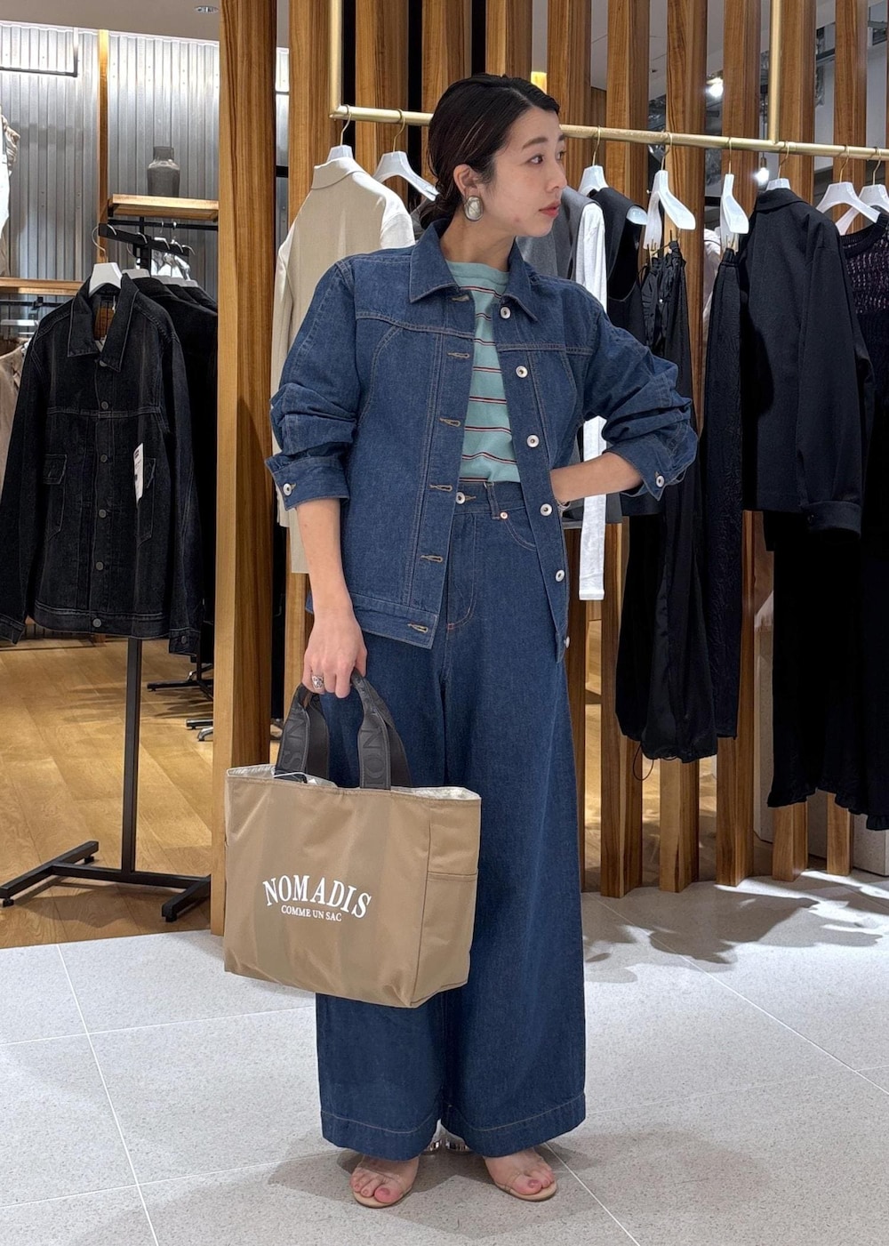 ベージュ系のハンドバッグ、ブルー系のTシャツ/カットソー、ブルー系のブルゾンを着用したレディースの冬コーディネートの2枚目の写真