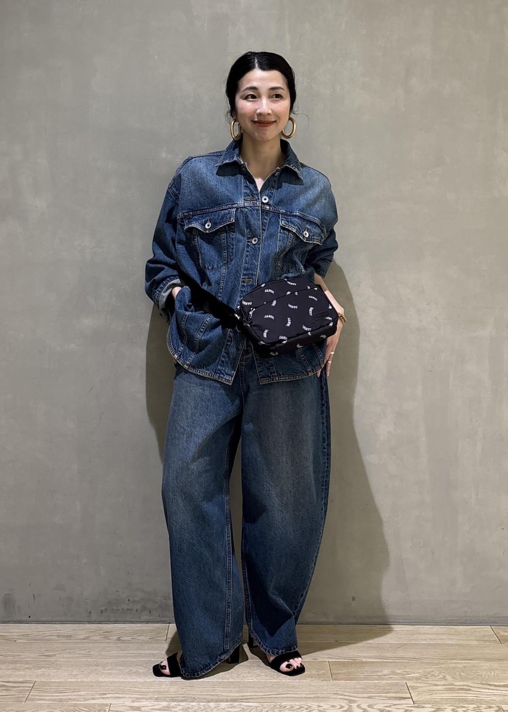 ブルー系のデニムジャケット、ブルー系のデニムパンツ、ブラック系のトートバッグを着用したレディースの春コーディネートの8枚目の写真