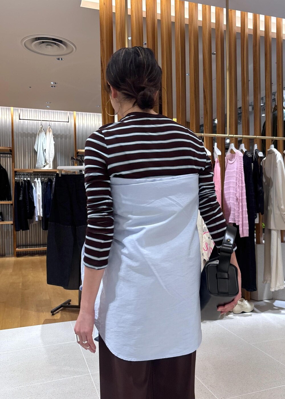 ブラック系のハンドバッグ、ブルー系のシャツ/ブラウス、ブラウン系のTシャツ/カットソーを着用したレディースの春コーディネートの10枚目の写真