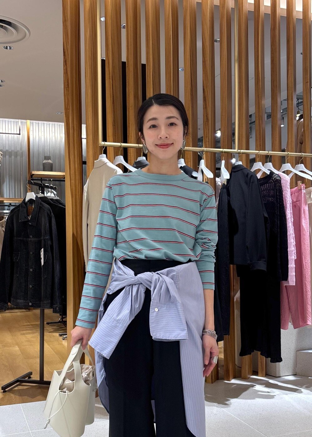 ホワイト系のパンプス、ブルー系のTシャツ/カットソー、ブルー系のシャツ/ブラウスを着用したレディースの冬コーディネートの9枚目の写真