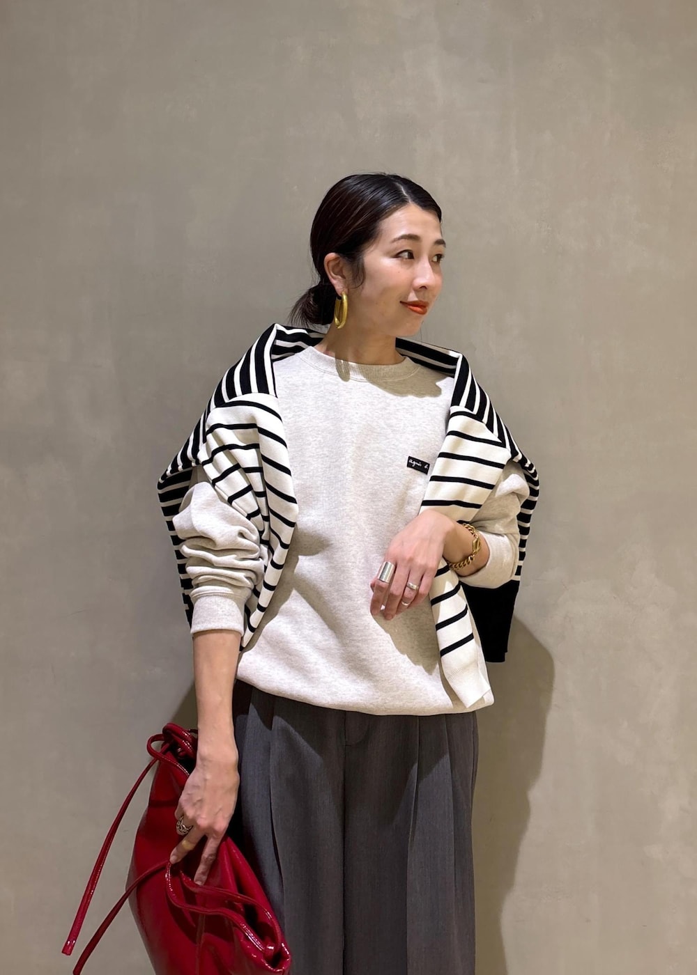 グレー系のスラックス、ホワイト系のスウェット、ブラック系のニット/セーターを着用したレディースの冬コーディネートの8枚目の写真