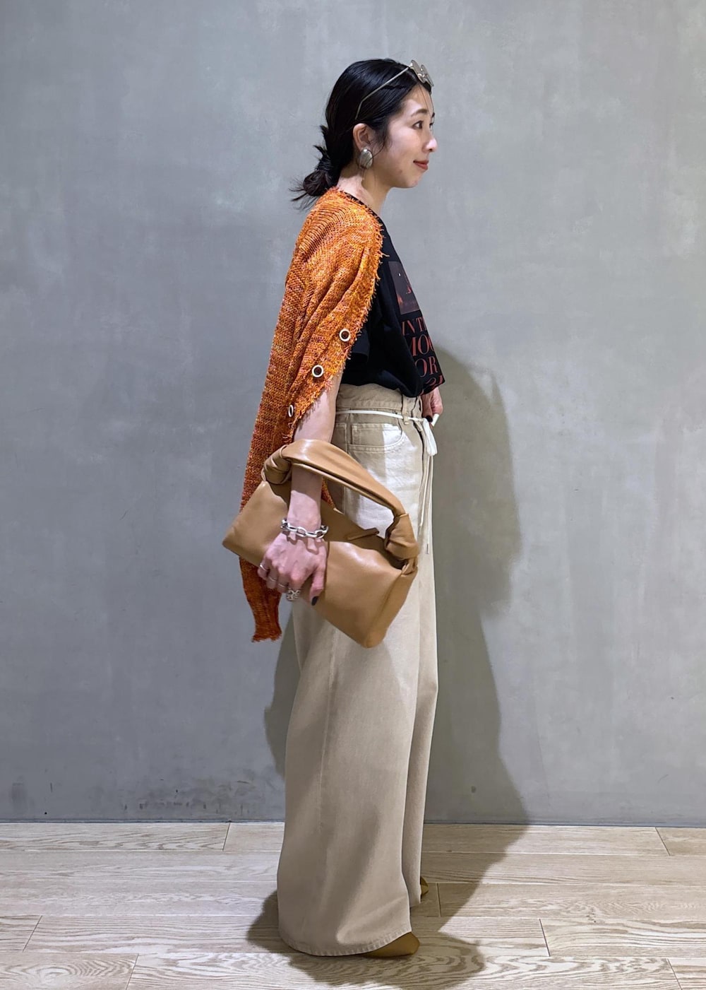 ベージュ系のハンドバッグ、ホワイト系のデニムパンツ、ホワイト系のTシャツ/カットソーを着用したレディースの春コーディネートの4枚目の写真