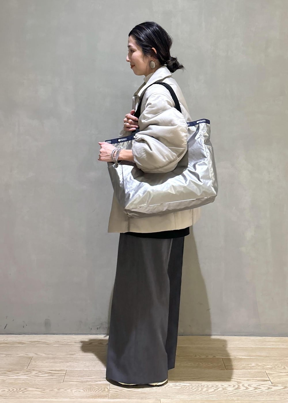 グレー系のスニーカー、ブラック系のシャツ/ブラウス、ベージュ系のブルゾンを着用したレディースの秋コーディネートの5枚目の写真