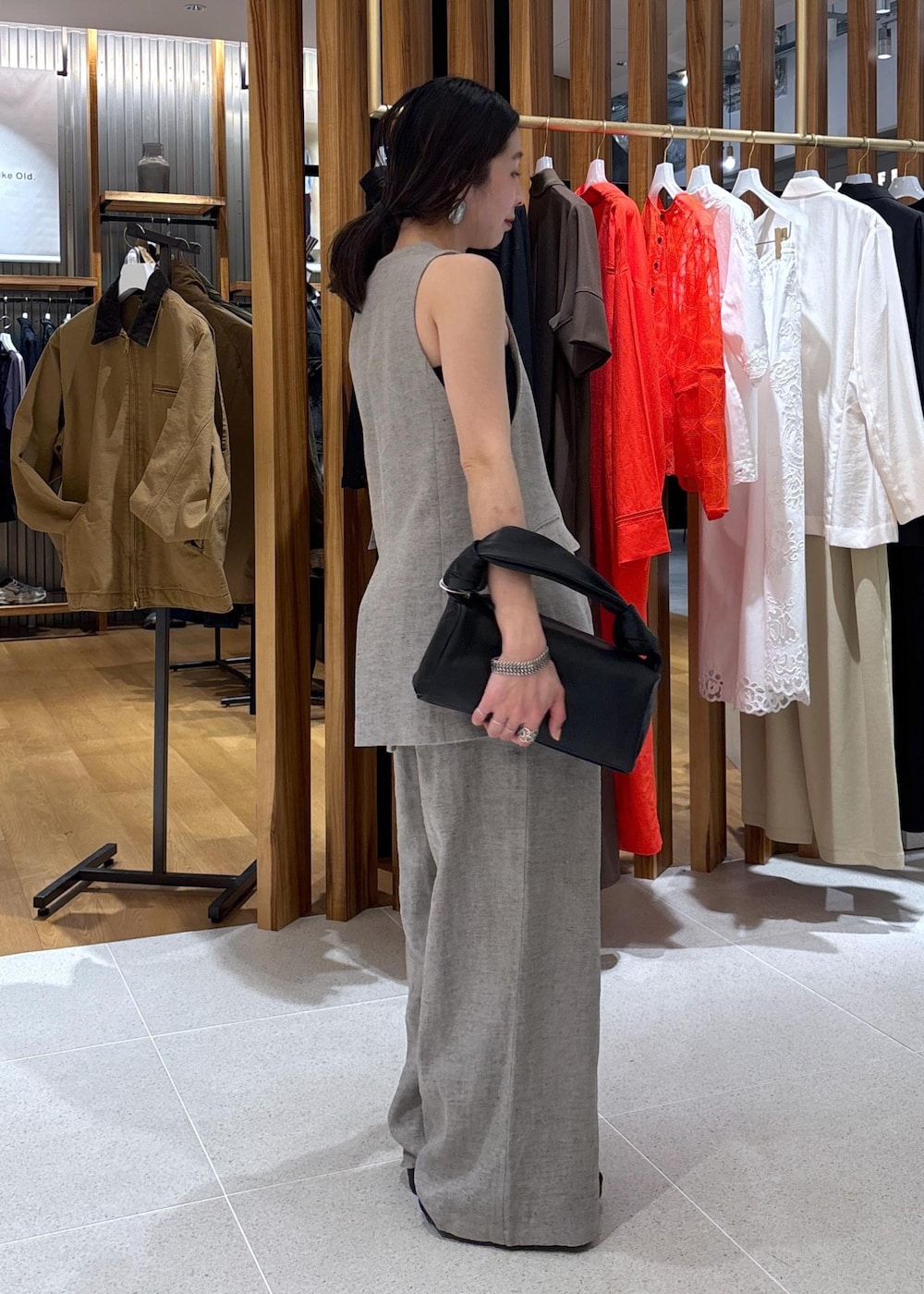 ブラック系のハンドバッグ、ベージュ系のその他パンツ、ベージュ系のベストを着用したレディースの春コーディネートの4枚目の写真