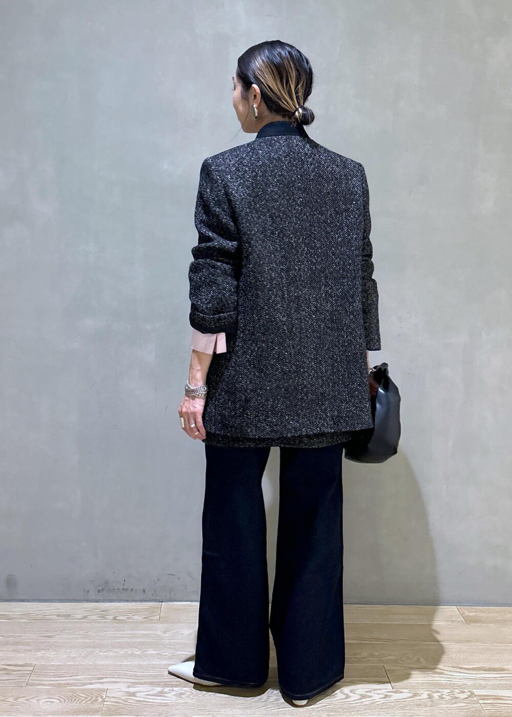 ブラック系のショルダーバッグ、ホワイト系のパンプス、ブルー系のデニムパンツを着用したレディースの夏コーディネートの5枚目の写真