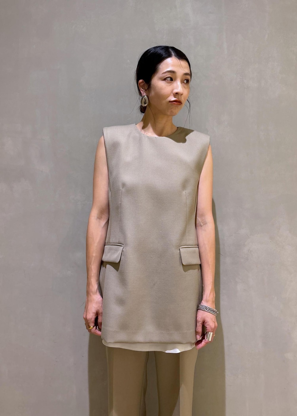 ブラック系のパンプス、ベージュ系のベスト、ベージュ系のスラックスを着用したレディースの夏コーディネートの8枚目の写真