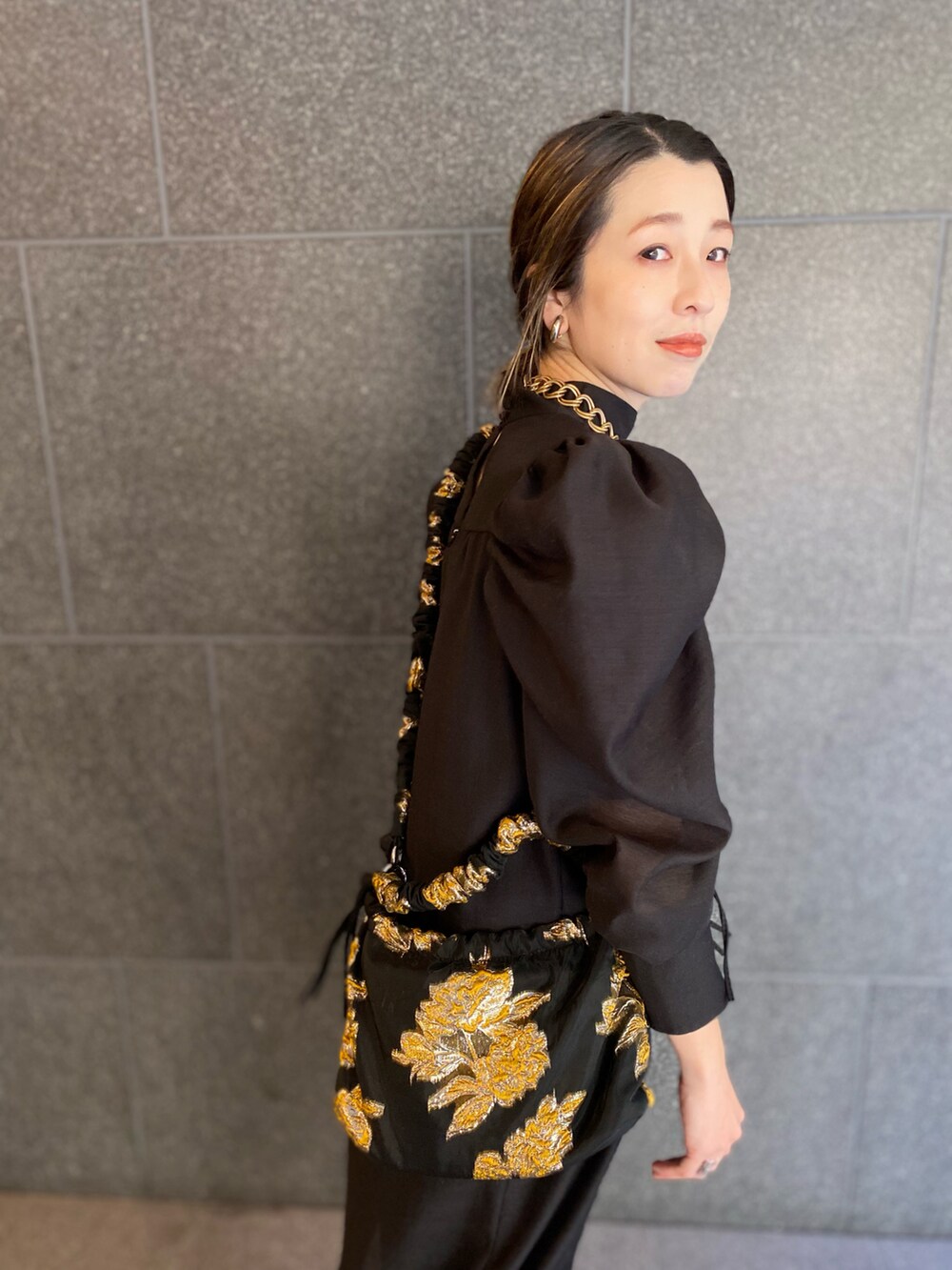 ブラック系のブーツ、ブラック系のワンピース、ブラック系のバッグを着用したレディースの春コーディネートの4枚目の写真