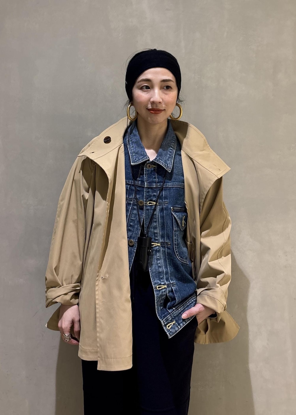 ベージュ系のトレンチコート、ブルー系のデニムジャケット、ブルー系のその他パンツを着用したレディースの春コーディネートの7枚目の写真