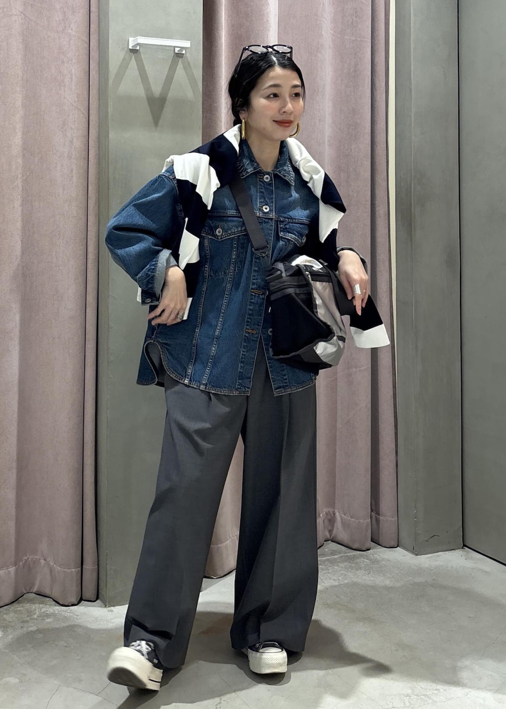 ブルー系のデニムジャケット、グレー系のスラックス、ブルー系のTシャツ/カットソーを着用したレディースの春コーディネートの3枚目の写真