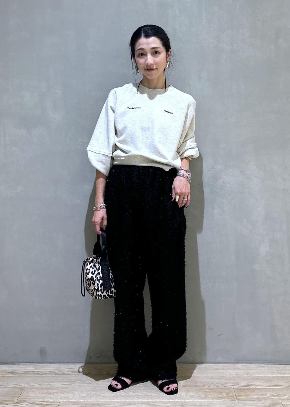 ブラウン系のハンドバッグ、ブラック系のその他パンツ、ホワイト系のスウェットを着用したレディースの夏コーディネートの2枚目の写真