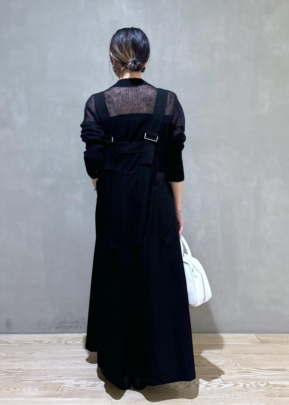 ホワイト系のボストンバッグ、ブラック系のワンピース、ブラック系のブーツを着用したレディースの秋コーディネートの5枚目の写真