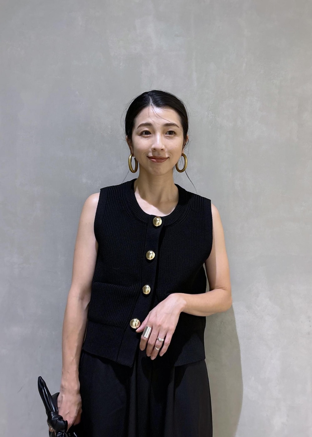 シルバー系のスニーカー、ブラック系のニット/セーター、ブラック系のショルダーバッグを着用したレディースの夏コーディネートの8枚目の写真