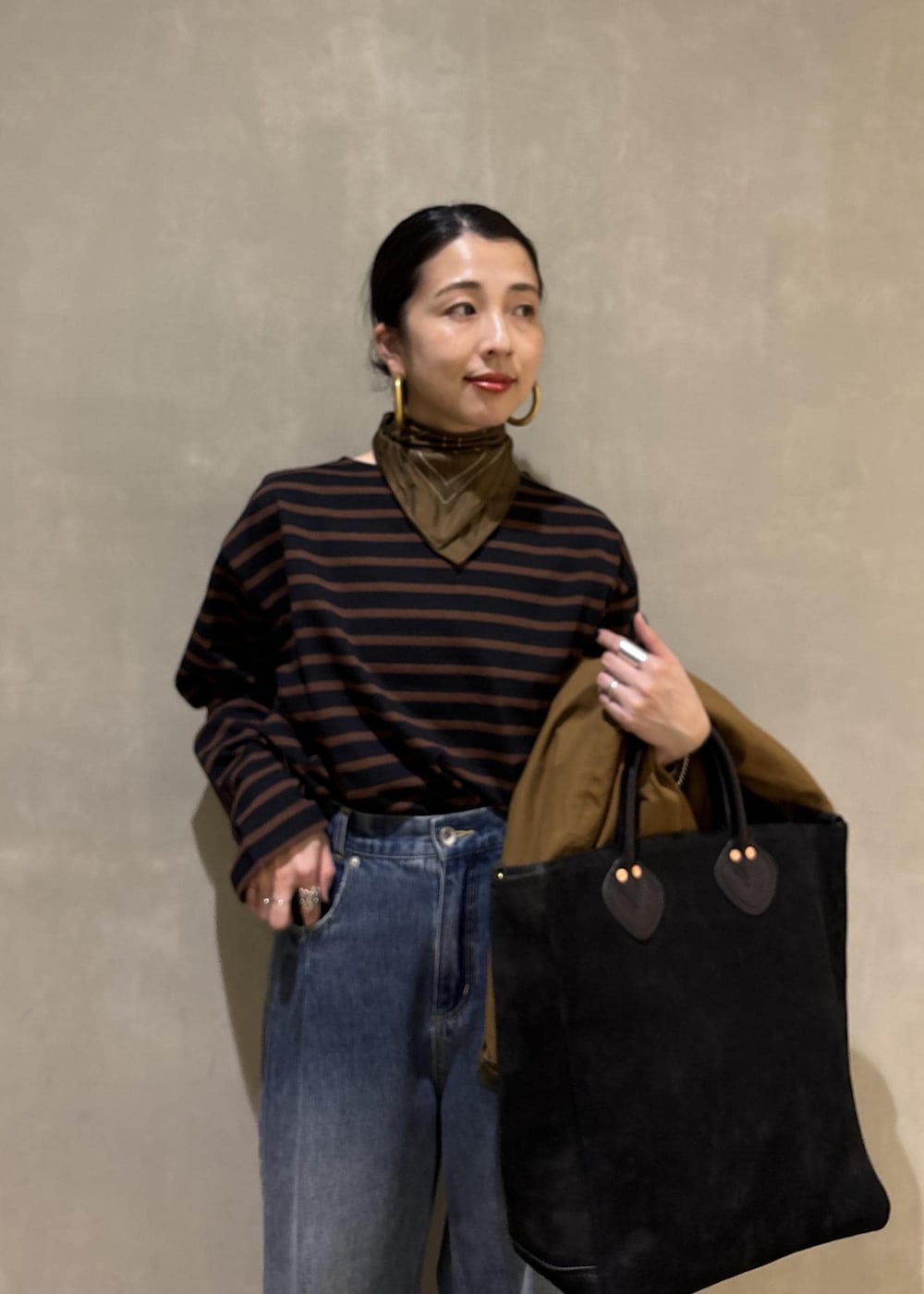 ブルー系のデニムパンツ、イエロー系のブルゾン、ブラウン系のTシャツ/カットソーを着用したレディースの夏コーディネートの9枚目の写真