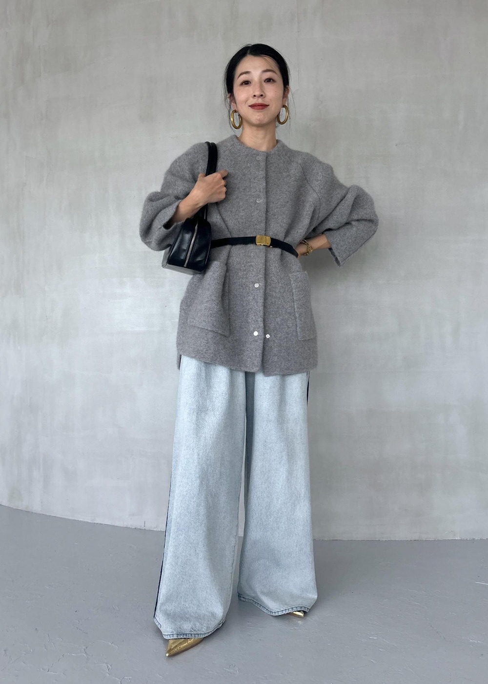 ゴールド系のパンプス、ブルー系のその他パンツ、ブラック系のボストンバッグを着用したレディースの秋コーディネートの2枚目の写真