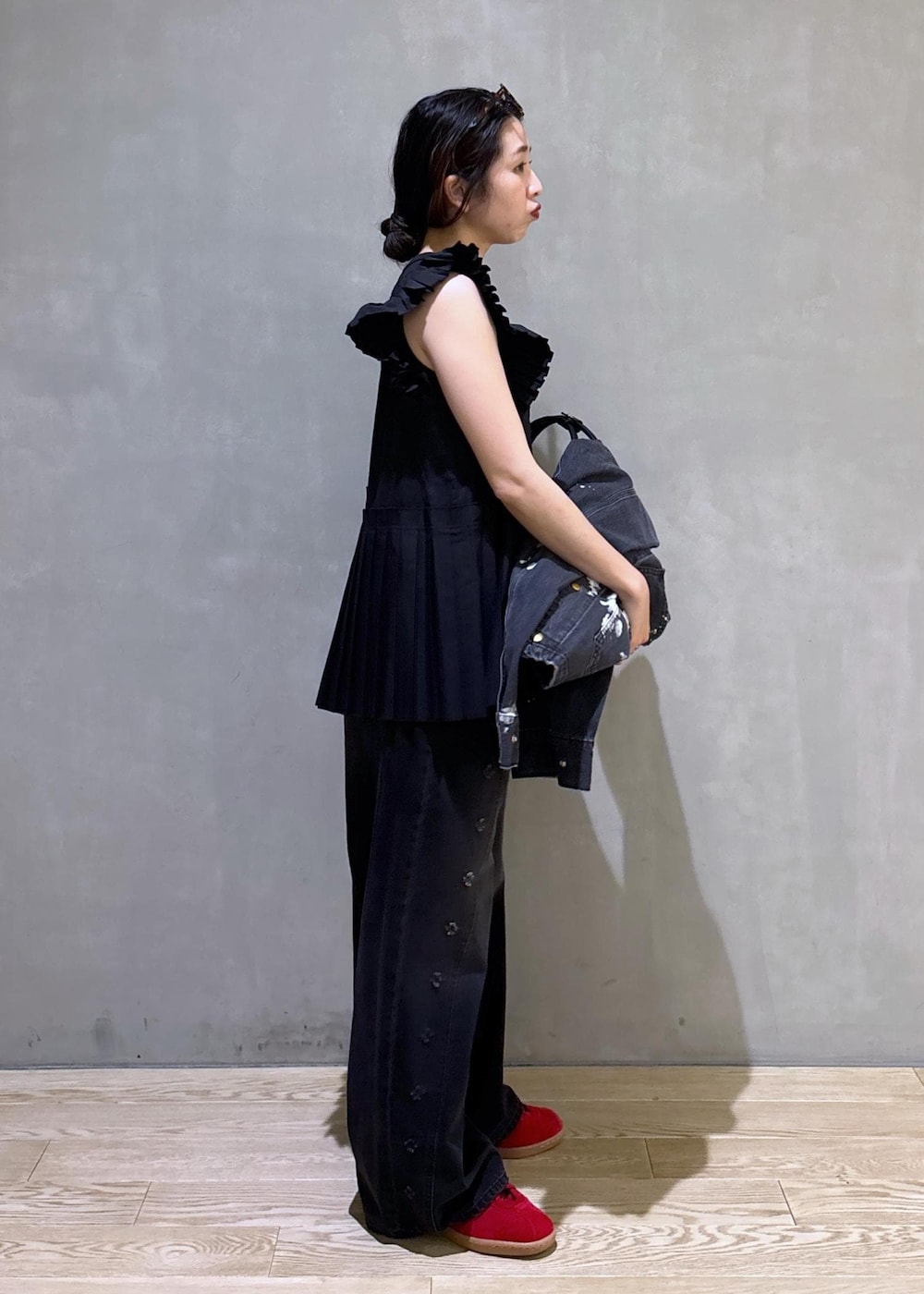 ブラック系のTシャツ/カットソー、ブラック系のデニムパンツ、ホワイト系のボストンバッグを着用したレディースの春コーディネートの3枚目の写真