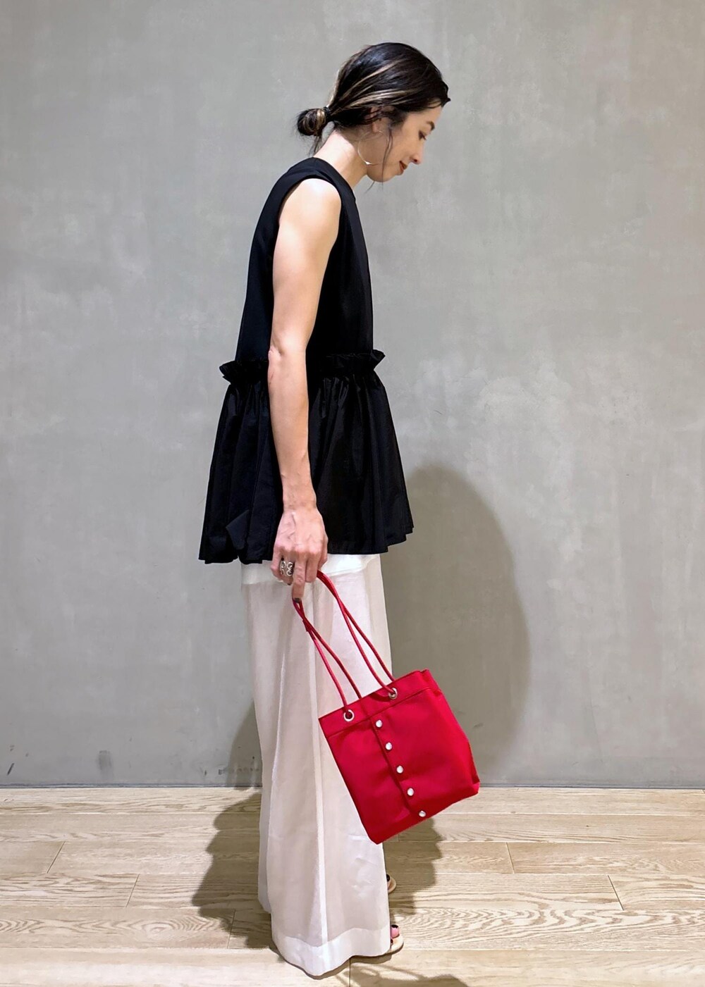ホワイト系のタンクトップ、ホワイト系のその他パンツ、レッド系のハンドバッグを着用したレディースの夏コーディネートの3枚目の写真