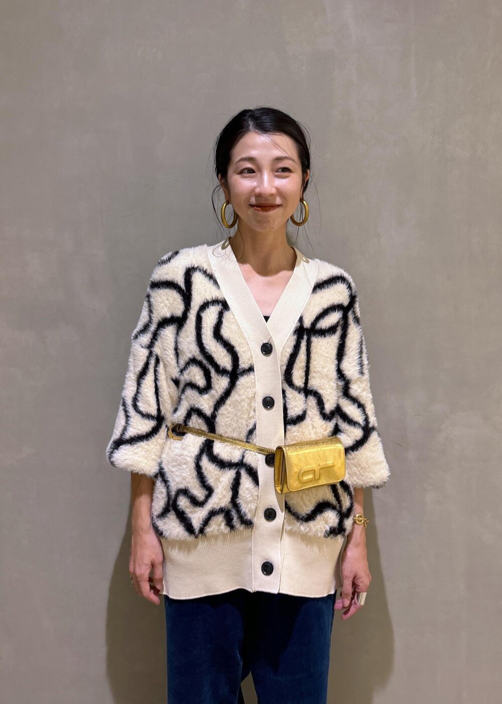 ゴールド系のその他シューズ、ゴールド系のショルダーバッグ、ホワイト系のカーディガン/ボレロを着用したレディースの秋コーディネートの8枚目の写真