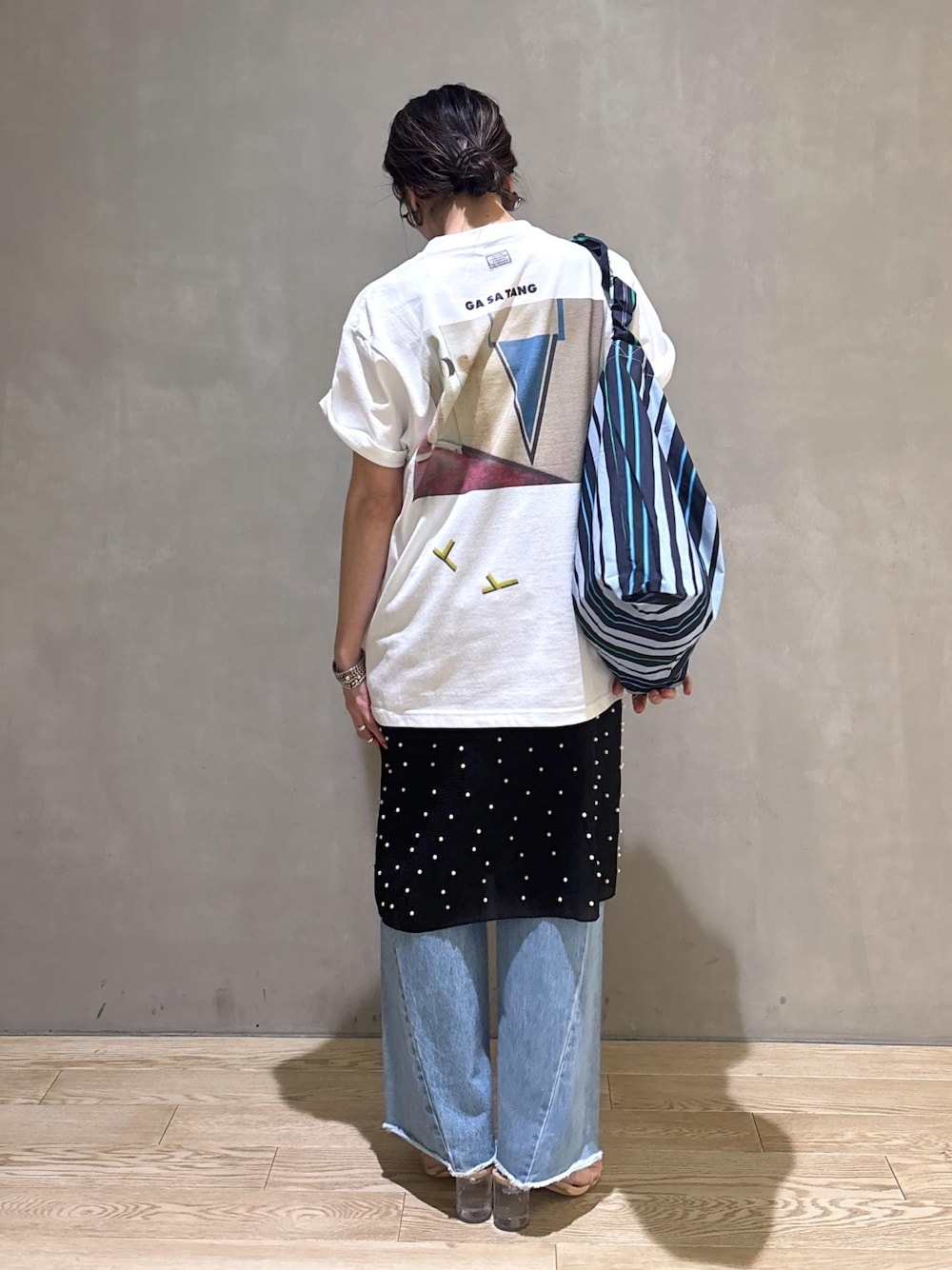 ブルー系のデニムパンツ、ブルー系のショルダーバッグ、ホワイト系のTシャツ/カットソーを着用したレディースの春コーディネートの7枚目の写真