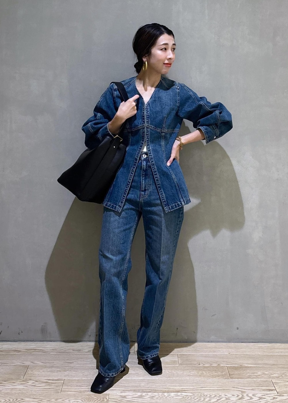 ブルー系のシャツ/ブラウス、ブルー系のデニムパンツ、ブラック系のショルダーバッグを着用したレディースの冬コーディネートの4枚目の写真