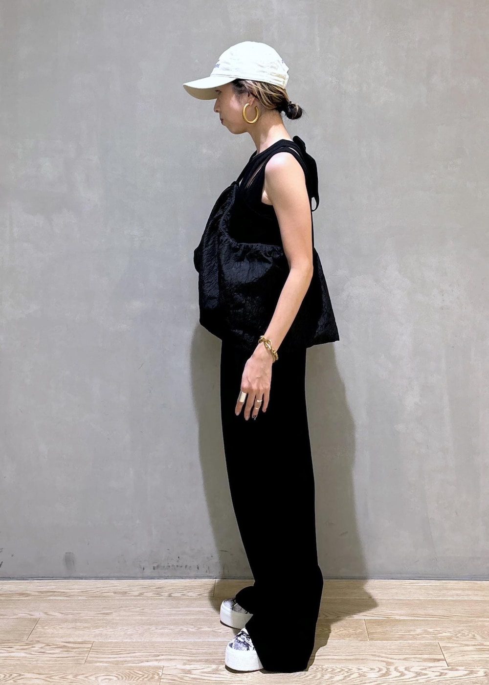 ブラック系のスニーカー、ブラック系のつなぎ/オールインワン、ベージュ系のキャップを着用したレディースの夏コーディネートの5枚目の写真