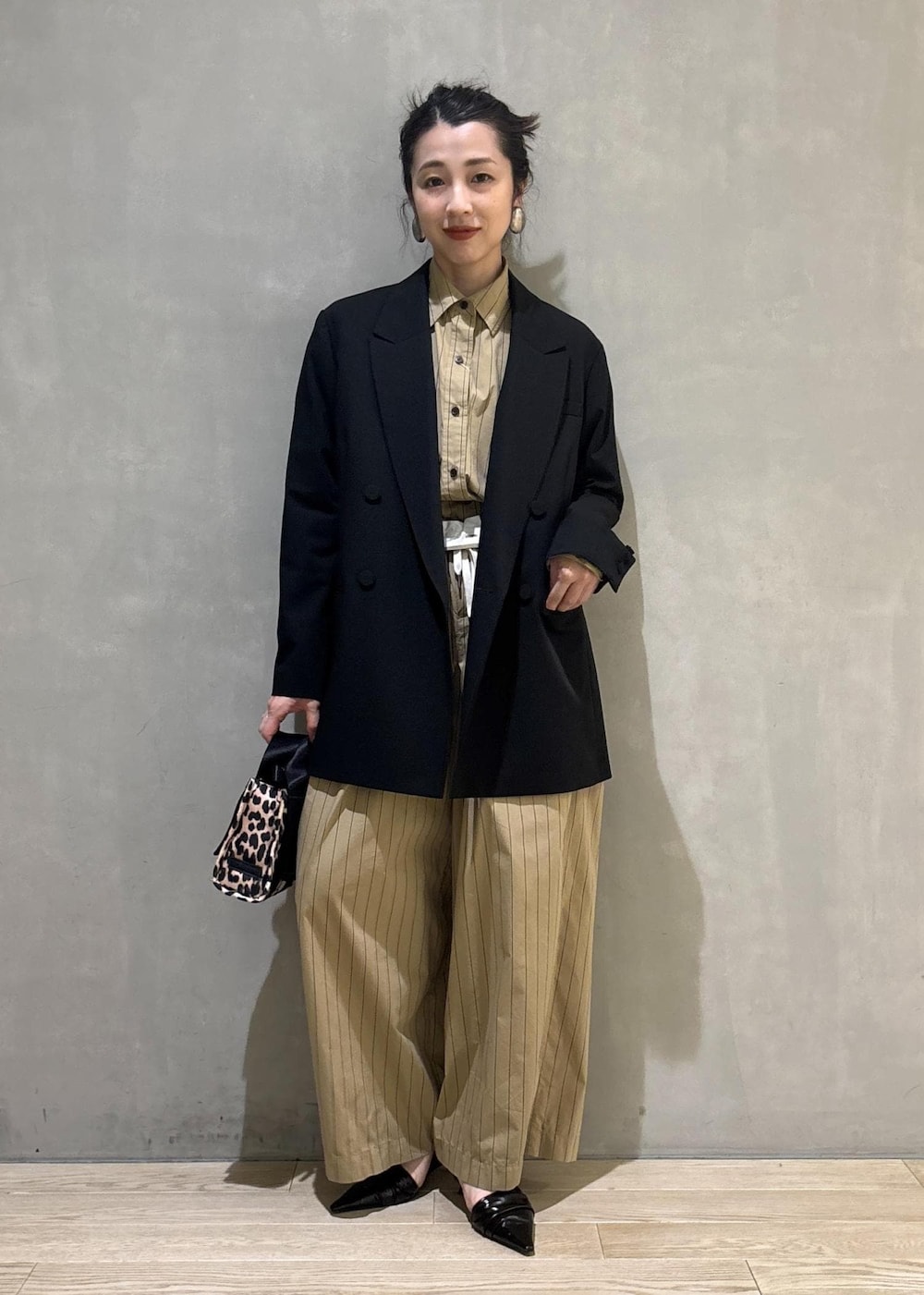 ベージュ系のショルダーバッグ、ベージュ系のスラックス、ベージュ系のシャツ/ブラウスを着用したレディースの秋コーディネートの6枚目の写真