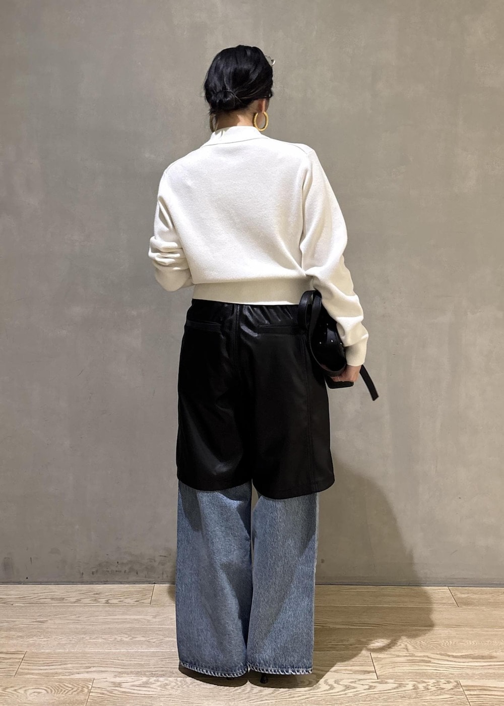 ブラック系のサンダル、ブルー系のデニムパンツ、ブラック系のダウンジャケット/コートを着用したレディースの冬コーディネートの7枚目の写真