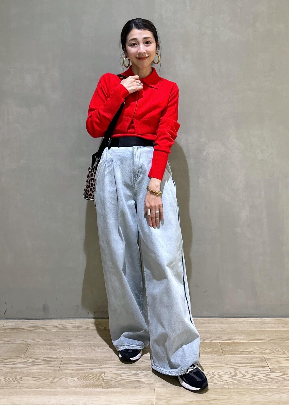 ベージュ系のトートバッグ、ブルー系のその他パンツ、レッド系のカーディガン/ボレロを着用したレディースの秋コーディネートの2枚目の写真