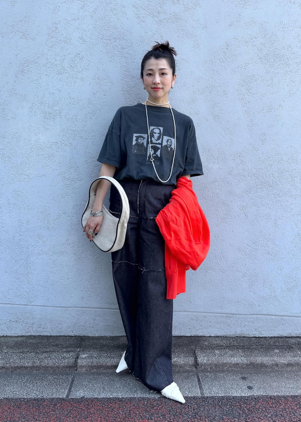 レッド系のシャツ/ブラウス、ブルー系のデニムパンツ、ホワイト系のハンドバッグを着用したレディースの夏コーディネートの3枚目の写真