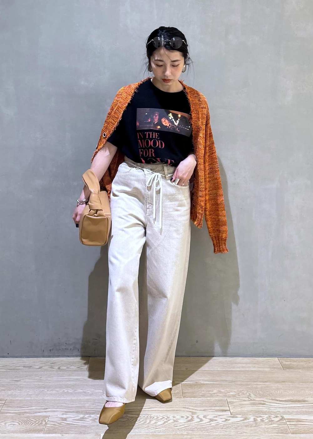 ベージュ系のハンドバッグ、ホワイト系のデニムパンツ、ホワイト系のTシャツ/カットソーを着用したレディースの春コーディネートの3枚目の写真