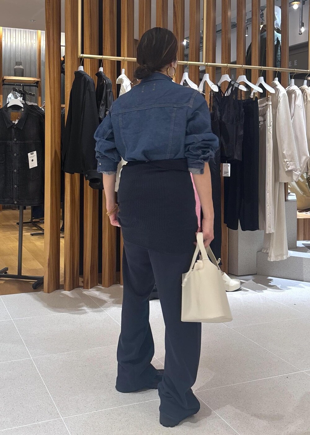 ブラック系のローファー、ホワイト系のハンドバッグ、ブルー系のブルゾンを着用したレディースの春コーディネートの4枚目の写真