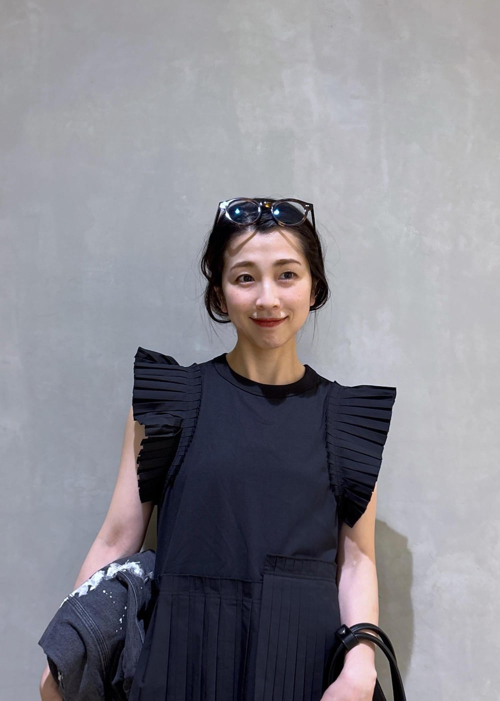 ブラック系のTシャツ/カットソー、ブラック系のデニムパンツ、ホワイト系のボストンバッグを着用したレディースの春コーディネートの8枚目の写真